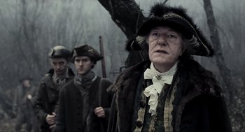 Movie still from “Sleepy Hollow” (1999), directed by Tim Burton – A group of people standing next to each other in a forest; Medium shot, Over the shoulder angle