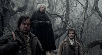 Movie still from “Sleepy Hollow” (1999), directed by Tim Burton – Two men and a woman standing next to each other in the woods; Medium shot, Low angle