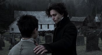 Movie still from “Sleepy Hollow” (1999), directed by Tim Burton – A man standing next to another man in a cemetery; Medium shot, Over the shoulder angle