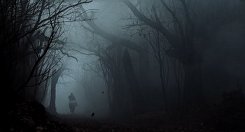 Movie still from “Sleepy Hollow” (1999), directed by Tim Burton – A person is walking through the woods in the fog; Extreme Wide shot, Low angle