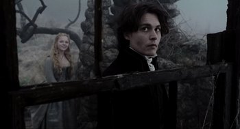 Movie still from “Sleepy Hollow” (1999), directed by Tim Burton – A man and a woman standing next to each other in front of a stone wall; Medium shot, Over the shoulder angle