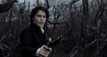 Movie still from “Sleepy Hollow” (1999), directed by Tim Burton – A man holding a gun in front of a forest; Close Up shot, Low angle