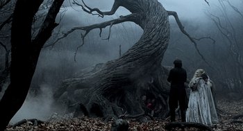 Movie still from “Sleepy Hollow” (1999), directed by Tim Burton – A man standing in front of a tree in the woods; Wide shot, Over the shoulder angle