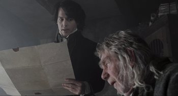 Movie still from “Sleepy Hollow” (1999), directed by Tim Burton – A man and a woman are reading a paper together; Close Up shot, Over the shoulder angle