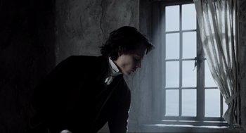 Movie still from “Sleepy Hollow” (1999), directed by Tim Burton – A young man in a black jacket is looking down; Medium shot, Low angle