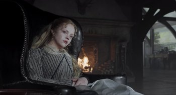 Movie still from “Sleepy Hollow” (1999), directed by Tim Burton – A girl sitting in a chair in front of a fire place; Medium shot, Low angle