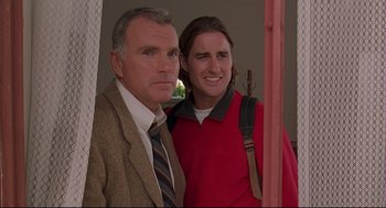 Movie still from “Bottle Rocket” (1996), directed by Wes Anderson – A man standing next to a woman in a red shirt; Medium shot, Low angle
