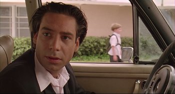 Movie still from “Bottle Rocket” (1996), directed by Wes Anderson – A man sitting in the back seat of a car looking out the window; Close Up shot, Over the shoulder angle