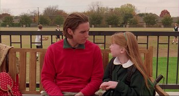 Movie still from “Bottle Rocket” (1996), directed by Wes Anderson – A man and a girl sitting on a park bench talking; Medium shot, Over the shoulder angle