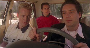 Movie still from “Bottle Rocket” (1996), directed by Wes Anderson – A group of men sitting in the back seat of a car; Medium shot, Low angle