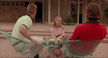 Movie still from “Bottle Rocket” (1996), directed by Wes Anderson – A group of people sitting at a table outside; Wide shot, High angle