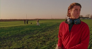 Movie still from “Bottle Rocket” (1996), directed by Wes Anderson – A group of people standing in a grassy field; Medium shot, Low angle