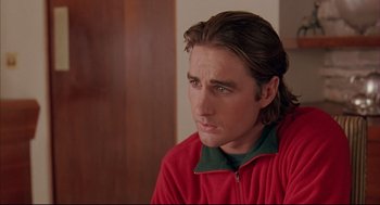 Movie still from “Bottle Rocket” (1996), directed by Wes Anderson – A man in a red jacket is looking at the camera; Close Up shot, Over the shoulder angle
