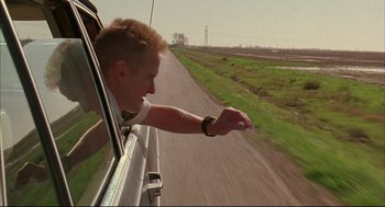 Movie still from “Bottle Rocket” (1996), directed by Wes Anderson – A man is pointing to the side of the road; Close Up shot, Low angle