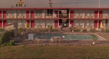 Movie still from “Bottle Rocket” (1996), directed by Wes Anderson – A motel with a swimming pool and lawn chairs; Extreme Wide shot, High angle
