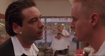 Movie still from “Bottle Rocket” (1996), directed by Wes Anderson – Two men in a barber shop one of which is looking at the other; Close Up shot, Over the shoulder angle