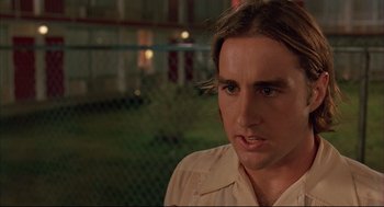 Movie still from “Bottle Rocket” (1996), directed by Wes Anderson – A person with long hair; Close Up shot, Over the shoulder angle