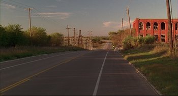 Movie still from “Bottle Rocket” (1996), directed by Wes Anderson – An empty road with power lines on both sides of the road; Extreme Wide shot, Low angle