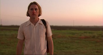 Movie still from “Bottle Rocket” (1996), directed by Wes Anderson – A man with a red nose standing in a field; Close Up shot, Low angle