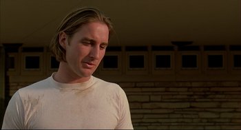 Movie still from “Bottle Rocket” (1996), directed by Wes Anderson – A person with long hair; Close Up shot, Low angle