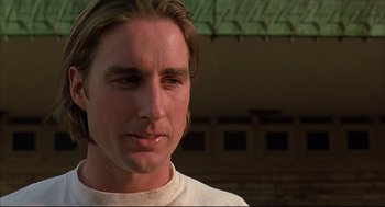 Movie still from “Bottle Rocket” (1996), directed by Wes Anderson – A person with long blonde hair; Close Up shot, Low angle