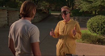 Movie still from “Bottle Rocket” (1996), directed by Wes Anderson – A man giving a thumbs up to another man wearing goggles; Medium shot, Low angle