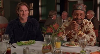 Movie still from “Bottle Rocket” (1996), directed by Wes Anderson – A group of people sitting at a table eating food; Medium shot, Over the shoulder angle