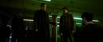 Movie still from “Snake Eyes” (2021), directed by Robert Schwentke – Two men are standing in a room and one of them is holding a cell phone; Medium shot, Low angle