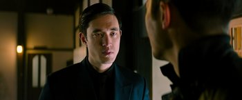 Movie still from “Snake Eyes” (2021), directed by Robert Schwentke – A man in a black suit talking to another man in a black suit; Close Up shot, Over the shoulder angle