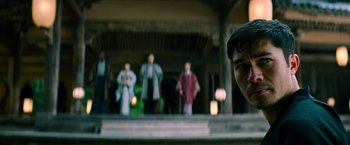 Movie still from “Snake Eyes” (2021), directed by Robert Schwentke – A group of people standing in front of a building; Close Up shot, Over the shoulder angle