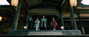 Movie still from “Snake Eyes” (2021), directed by Robert Schwentke – A group of people standing on steps in front of a building; Wide shot, Low angle