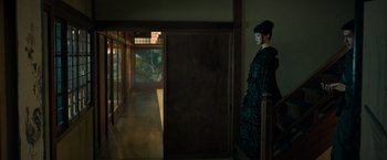 Movie still from “Snake Eyes” (2021), directed by Robert Schwentke – A woman standing in front of an open door; Wide shot, Over the shoulder angle