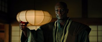 Movie still from “Snake Eyes” (2021), directed by Robert Schwentke – A black man in a striped shirt and jacket; Close Up shot, Low angle