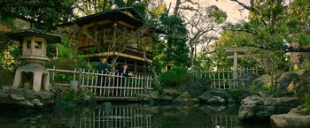 Movie still from “Snake Eyes” (2021), directed by Robert Schwentke – Two men are standing on a bridge near a pond; Extreme Wide shot, Low angle