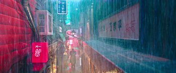 Movie still from “Snake Eyes” (2021), directed by Robert Schwentke – A person walking down a street in the rain; Extreme Wide shot, High angle
