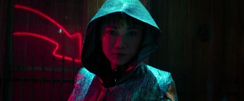 Movie still from “Snake Eyes” (2021), directed by Robert Schwentke – A woman wearing a silver jacket with a hood; Close Up shot, High angle