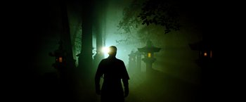 Movie still from “Snake Eyes” (2021), directed by Robert Schwentke – A man standing in the fog with a light shining on his head; Wide shot, Low angle