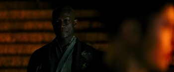 Movie still from “Snake Eyes” (2021), directed by Robert Schwentke – A man in a suit and tie looking at the camera; Close Up shot, Over the shoulder angle