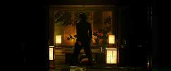 Movie still from “Snake Eyes” (2021), directed by Robert Schwentke – A man holding a sword in front of a painting; Wide shot, Low angle