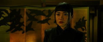 Movie still from “Snake Eyes” (2021), directed by Robert Schwentke – A woman in a black jacket standing in front of a wall; Close Up shot, Low angle