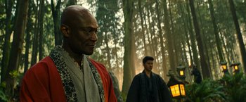 Movie still from “Snake Eyes” (2021), directed by Robert Schwentke – Two men in traditional garb standing in the woods; Close Up shot, Over the shoulder angle