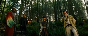 Movie still from “Snake Eyes” (2021), directed by Robert Schwentke – A person in a forest with trees in the background; Wide shot, Low angle