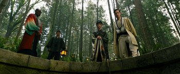 Movie still from “Snake Eyes” (2021), directed by Robert Schwentke – A group of people standing in the forest; Wide shot, Low angle