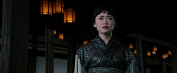 Movie still from “Snake Eyes” (2021), directed by Robert Schwentke – A woman wearing a black and silver outfit; Close Up shot, Low angle