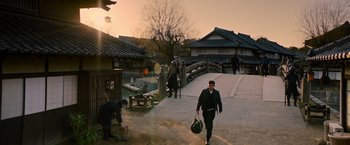 Movie still from “Snake Eyes” (2021), directed by Robert Schwentke – A man walking across a bridge carrying luggage; Extreme Wide shot, High angle