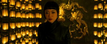 Movie still from “Snake Eyes” (2021), directed by Robert Schwentke – A woman in a black leather jacket standing in front of a dragon; Close Up shot, Low angle