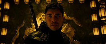 Movie still from “Snake Eyes” (2021), directed by Robert Schwentke – A person holding a sword in a room; Close Up shot, Low angle