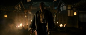 Movie still from “Snake Eyes” (2021), directed by Robert Schwentke – A man wearing a robe and a kimono standing in front of a building at night; Medium shot, Low angle