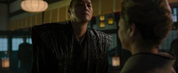 Movie still from “Snake Eyes” (2021), directed by Robert Schwentke – A man wearing a black shirt and a gold necklace; Close Up shot, Over the shoulder angle