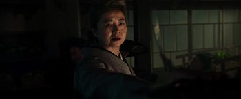 Movie still from “Snake Eyes” (2021), directed by Robert Schwentke – A woman in a dark room looking at the camera; Close Up shot, Low angle